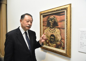 2014年に新たにコレクションに加わった中西勝「大地の中の母子」と館長の越智裕二郎さん