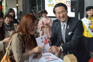 抽選会で松葉がにの目録を手渡しする平井伸治鳥取県知事